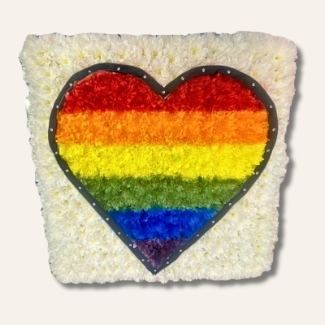 Pride heart-shaped funeral tribute made with white chrysanthemum, hand-sprayed in rainbow colours, finished with black ribbon trim and diamanté details on a 24