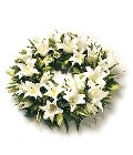 Classic round funeral wreath with oriental lilies and complementary mixed foliage, offering an elegant and dramatic tribute.